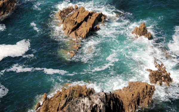 A stunning 4K Ultra HD seascape of waves crashing against rugged coastal rocks, capturing the dynamic beauty of nature in vibrant detail.