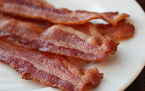 HD wallpaper featuring crispy bacon strips on a white plate, providing a savory-themed background.