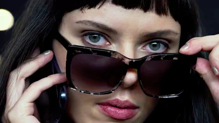 HD PC desktop wallpaper featuring Scarlett Johansson as Lucy, with intense eyes framed by dark sunglasses and a bold, cinematic look.