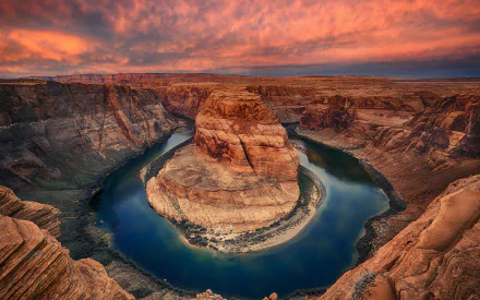 HD desktop wallpaper showcasing Horseshoe Bend's dramatic river curve surrounded by rugged cliffs under a vibrant sunset sky in a natural landscape.