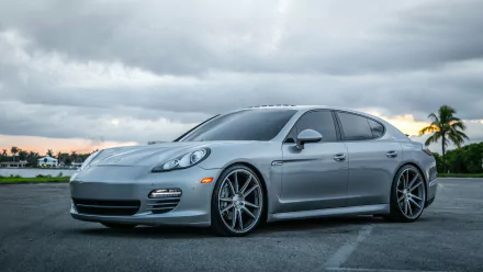 Sleek silver Porsche Panamera parked on an open road under a cloudy sky, captured in HD quality as a desktop wallpaper and background.