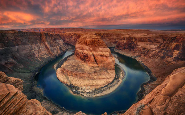 HD desktop wallpaper showcasing Horseshoe Bend's dramatic river curve surrounded by rugged cliffs under a vibrant sunset sky in a natural landscape.