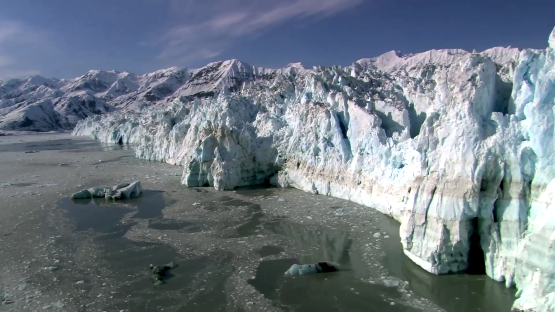 HD desktop wallpaper showcasing a vast icefloe with towering glaciers set against a partly cloudy sky in a pristine natural environment.