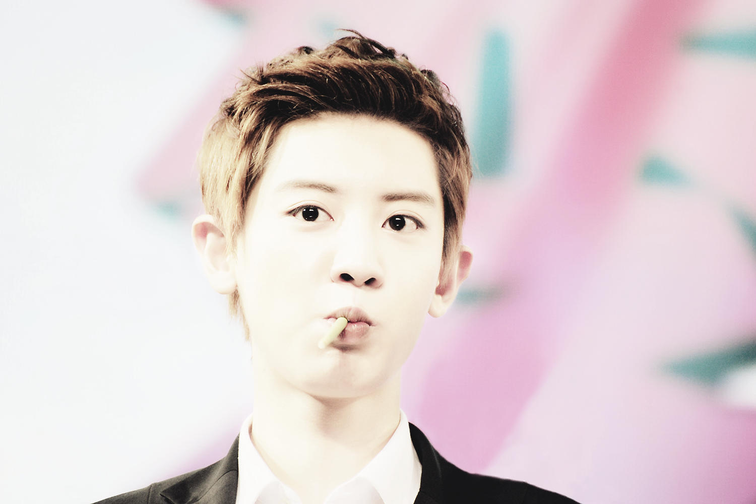 A young man with short, styled hair makes a playful expression, featured in a vibrant HD wallpaper celebrating music and EXO. The background adds a dynamic flair.