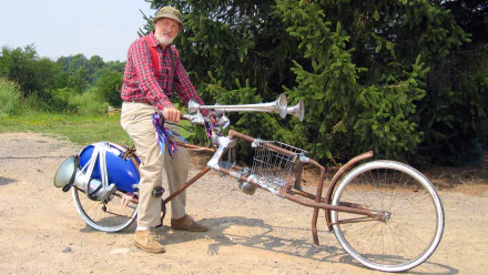 HD PC desktop wallpaper: man in plaid shirt and cap beside a homemade lowrider bicycle with horns on a rural path; tagged TV show The Red Green Show.