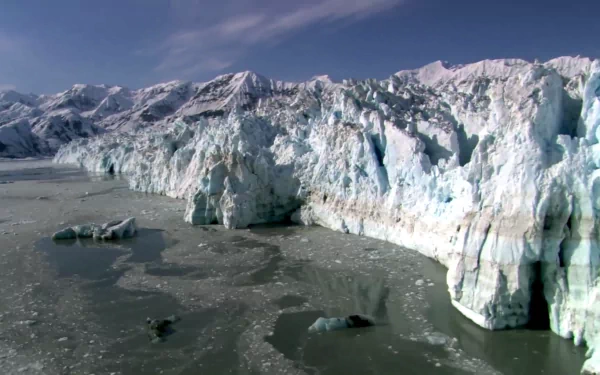 HD desktop wallpaper showcasing a vast icefloe with towering glaciers set against a partly cloudy sky in a pristine natural environment.