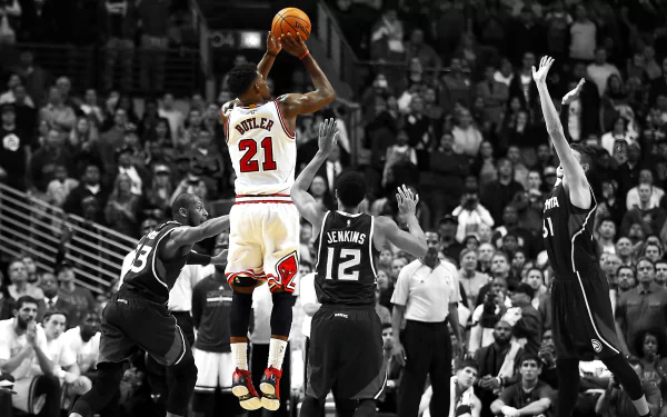 Jimmy Butler of the Chicago Bulls takes a shot during a game, captured in an HD wallpaper featuring intense action and vibrant sports energy.