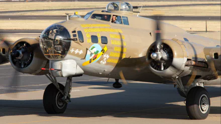 HD PC desktop wallpaper/background: military bomber taxiing on runway, close-up of vivid aircraft nose art, twin radial engines, landing gear and crew visible in the cockpit.
