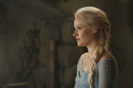 A side profile of Elsa from Once Upon A Time, featuring her iconic braid and shimmering outfit, set in a dimly lit environment. HD wallpaper for fans of the TV show.