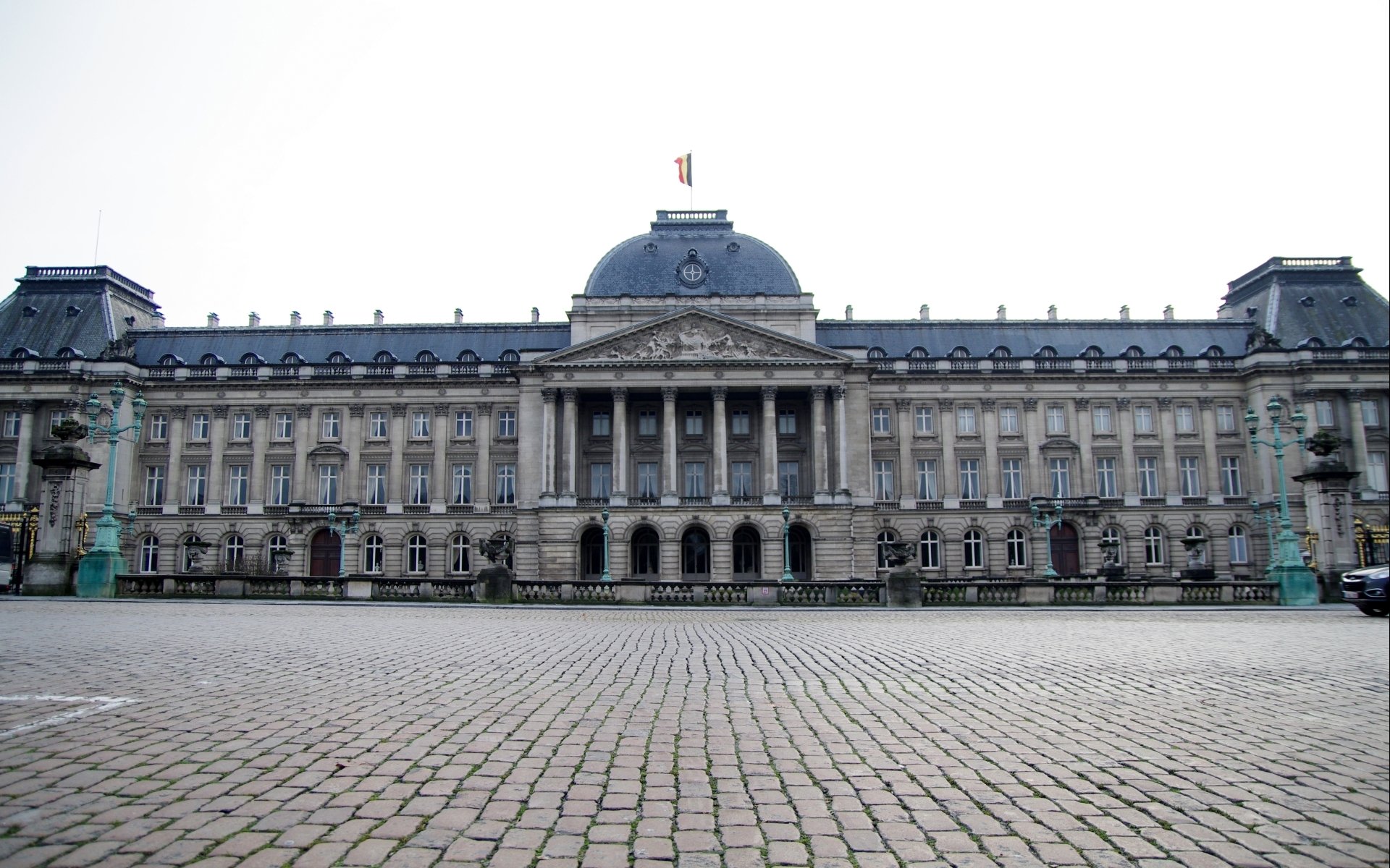 HD desktop wallpaper showcasing the grand Royal Palace of Brussels, a stunning man-made architectural landmark with detailed facades and a cobblestone foreground.