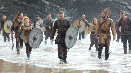 Vikings (2013) TV show scene featuring warriors with shields walking on a beach, captured in HD for a PC desktop wallpaper background.