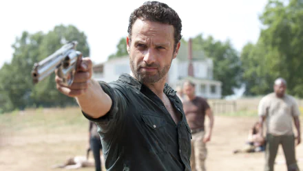 Rick Grimes, played by Andrew Lincoln, aims a gun in a tense scene from the TV show The Walking Dead, captured in this striking HD desktop wallpaper.