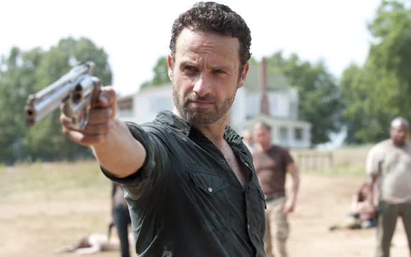 Rick Grimes, played by Andrew Lincoln, aims a gun in a tense scene from the TV show The Walking Dead, captured in this striking HD desktop wallpaper.