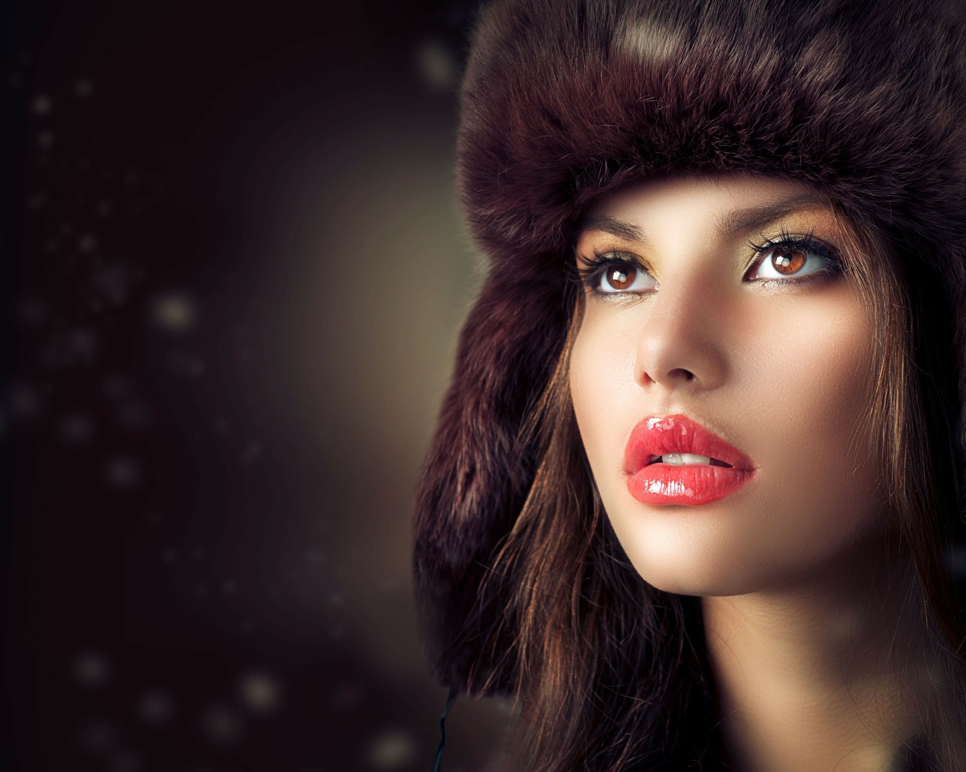 HD desktop wallpaper featuring a woman, tagged as Judy Wilkins, looking upwards with a neutral background. She is wearing a dark fur hat and has vibrant red lipstick.