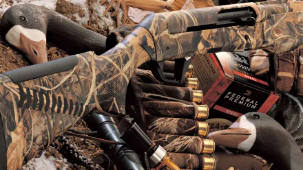HD desktop wallpaper featuring a camouflaged man-made shotgun surrounded by shotgun shells and hunting accessories.