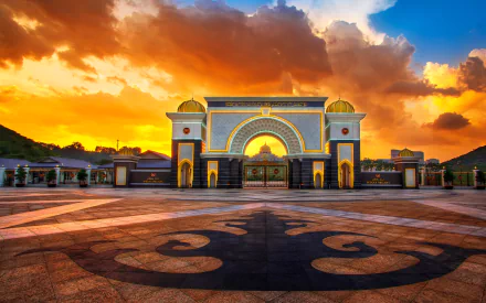 HD desktop wallpaper featuring the man-made Istana Negara in Jakarta, illuminated under a dramatic sunset sky with vibrant clouds.