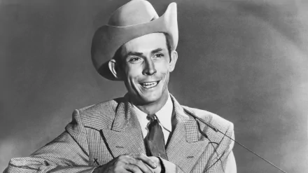 Black-and-white 4K Ultra HD PC desktop wallpaper of a smiling man in a cowboy hat and suit, holding a guitar — vintage music-themed background.