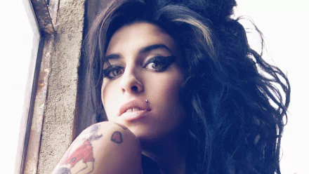 HD desktop wallpaper of English singer Amy Winehouse, featuring her iconic hairstyle and expressive gaze, capturing the essence of her music and style.