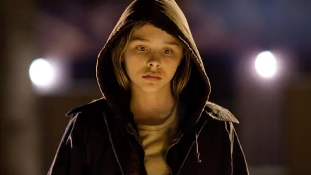 Chloë Grace Moretz stars in Let Me In, captured in a haunting moment in this HD PC desktop wallpaper, showcasing her evocative performance in the film.