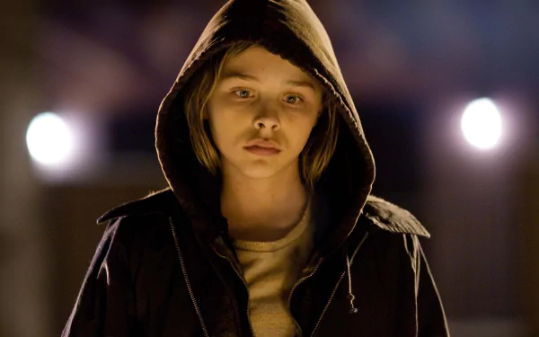 Chloë Grace Moretz stars in Let Me In, captured in a haunting moment in this HD PC desktop wallpaper, showcasing her evocative performance in the film.
