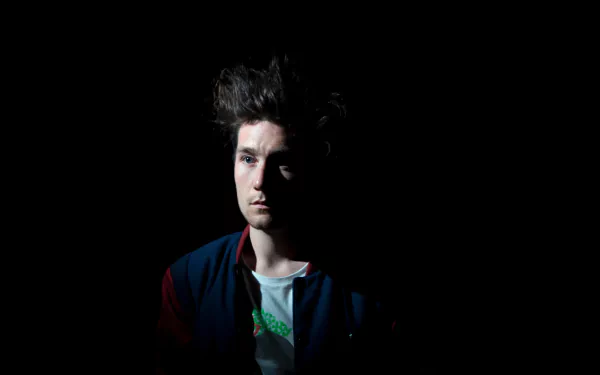 Portrait of a Bastille band member against a dark background, featured in a 4K Ultra HD English rock band desktop wallpaper.
