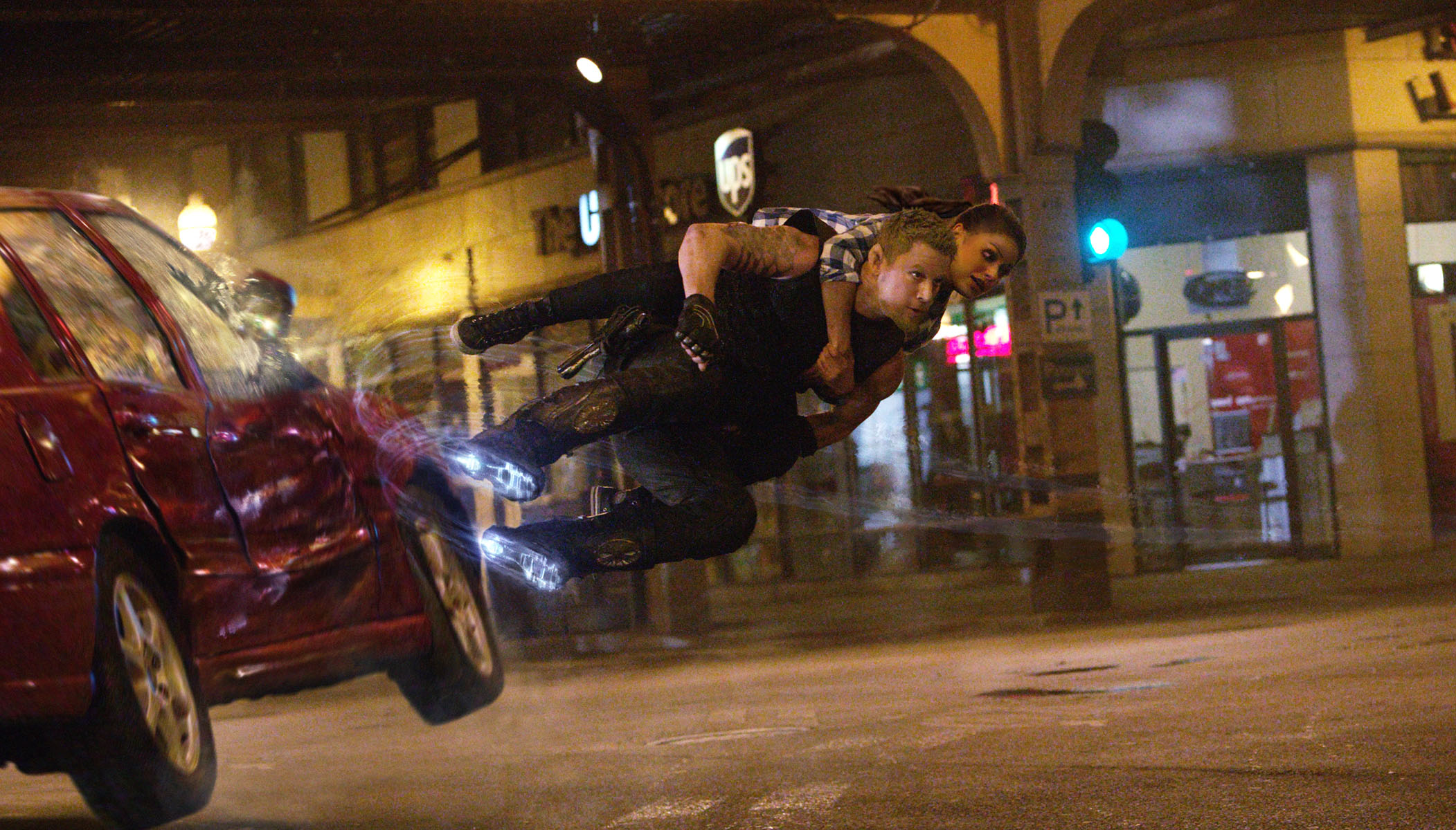 HD desktop wallpaper from Jupiter Ascending featuring a character in dynamic mid-air action above a city street at night.