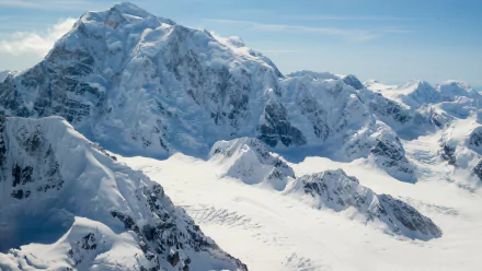 Snow-covered mountain peaks in Alaska during winter, captured in stunning 4K Ultra HD showcasing the pristine natural beauty of the snowy mountain landscape.