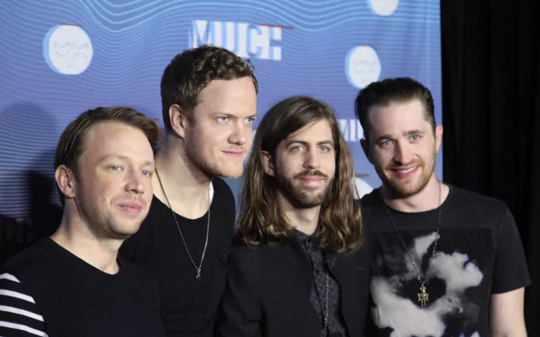 An image featuring the American alternative band Imagine Dragons, showcasing the group in stylish attire against a backdrop with a modern design, suitable as a vibrant 4K Ultra HD desktop wallpaper.