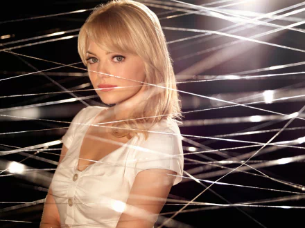 A woman with blonde hair poses amidst intricate strands of webbing, capturing the essence of The Amazing Spider-Man in this high-definition desktop wallpaper.