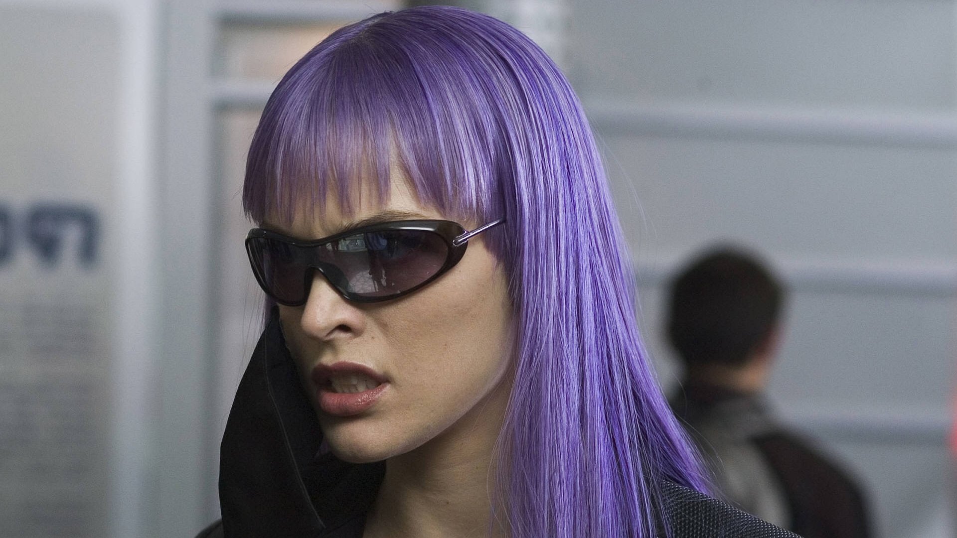 Close-up of a woman with straight violet hair and dark sunglasses; cinematic still from the movie Ultraviolet, 2K Quad HD PC desktop wallpaper.