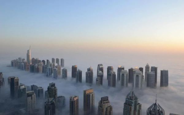 2K Quad HD PC wallpaper of Dubai's Sheikh Zayed Avenue: skyscrapers piercing dense fog at sunrise, man-made towers emerging from a sea of clouds.