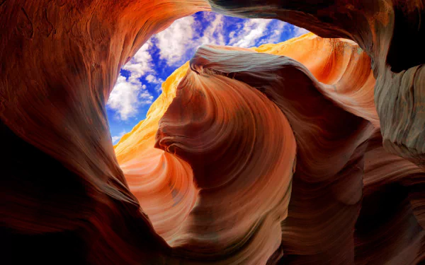 HD desktop wallpaper featuring the vibrant orange curves of Antelope Canyon contrasted with a vivid blue sky.