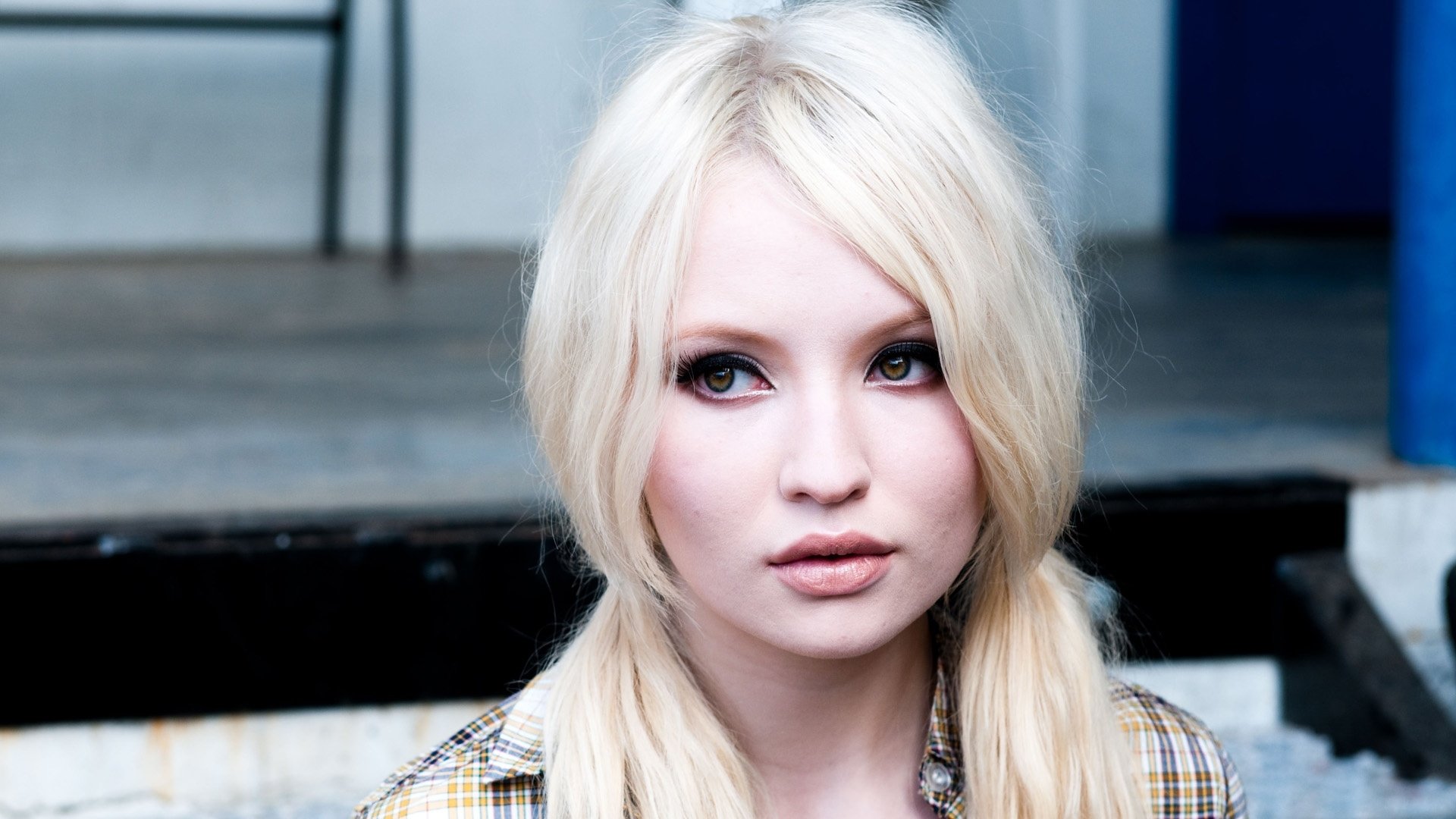 HD PC desktop wallpaper/background: close-up of a blonde female celebrity with pale skin and smoky eye makeup, soft expression, blurred urban steps behind.