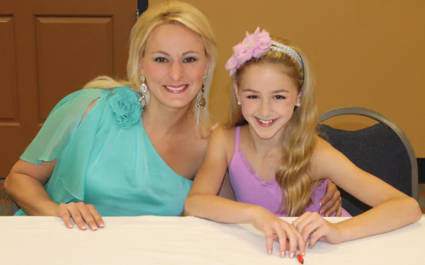 HD desktop wallpaper from Dance Moms with two smiling individuals at an event.
