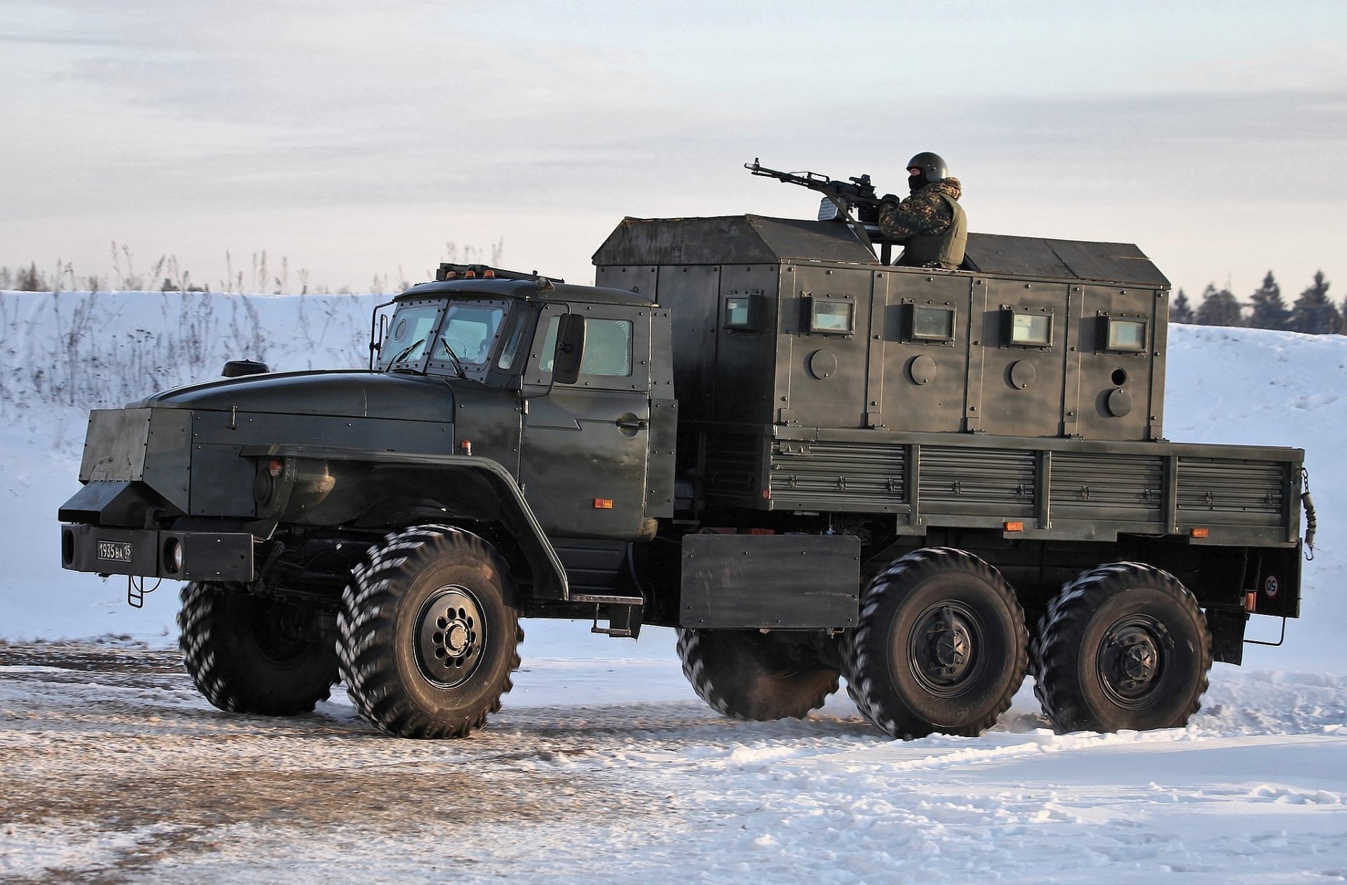HD PC desktop wallpaper featuring a military vehicle with a soldier on top, set in a snowy landscape under a cloudy sky.