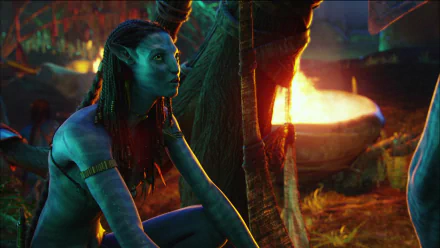 HD PC desktop wallpaper featuring a scene from the movie Avatar with a blue Na'vi character beside a glowing fire in a vibrant, detailed environment.