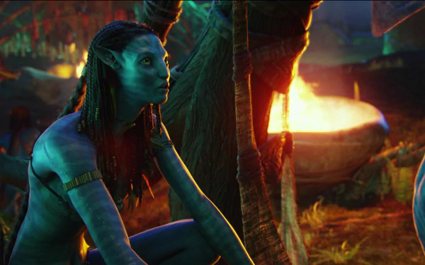 HD PC desktop wallpaper featuring a scene from the movie Avatar with a blue Na'vi character beside a glowing fire in a vibrant, detailed environment.