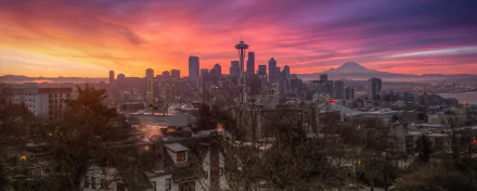 HD desktop wallpaper showcasing Seattle’s man-made skyline at sunset with the Space Needle and Mount Rainier in the background under a vibrant purple and orange sky.