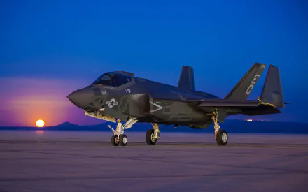 A Lockheed Martin F-35 Lightning II stands on an airstrip at sunset, capturing the power and elegance of military aviation in this stunning HD desktop wallpaper.
