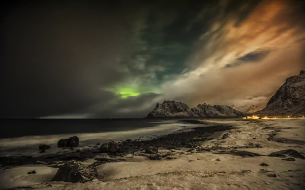 HD desktop wallpaper featuring the Northern Lights over a snowy beach in the Lofoten Islands, Norway, showcasing a dramatic arctic landscape.