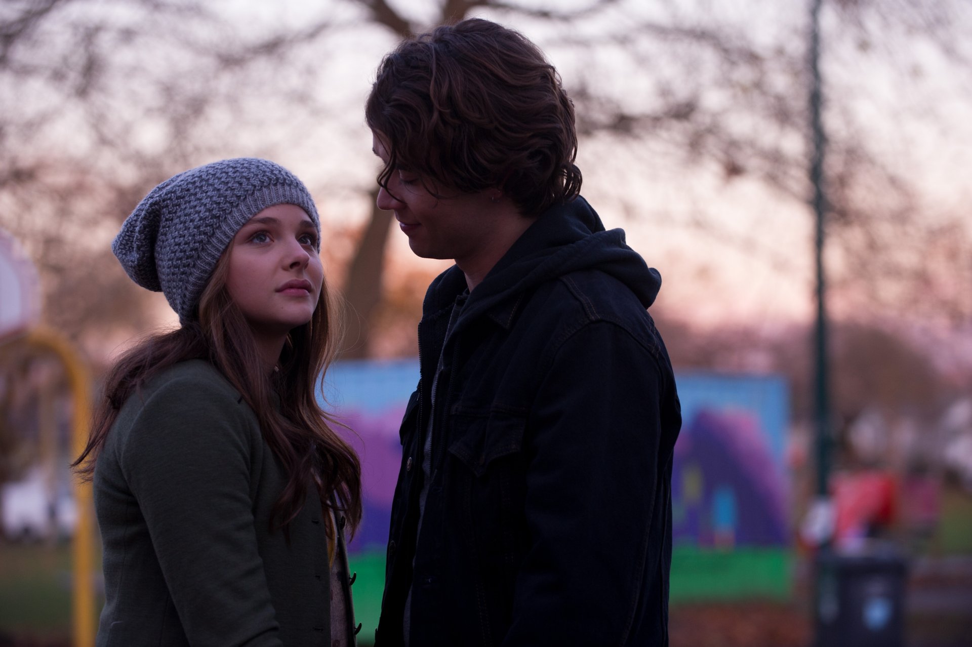 Two teens in winter coats facing each other at dusk, cinematic moment from the movie If I Stay — 5K Ultra HD PC desktop wallpaper and background.