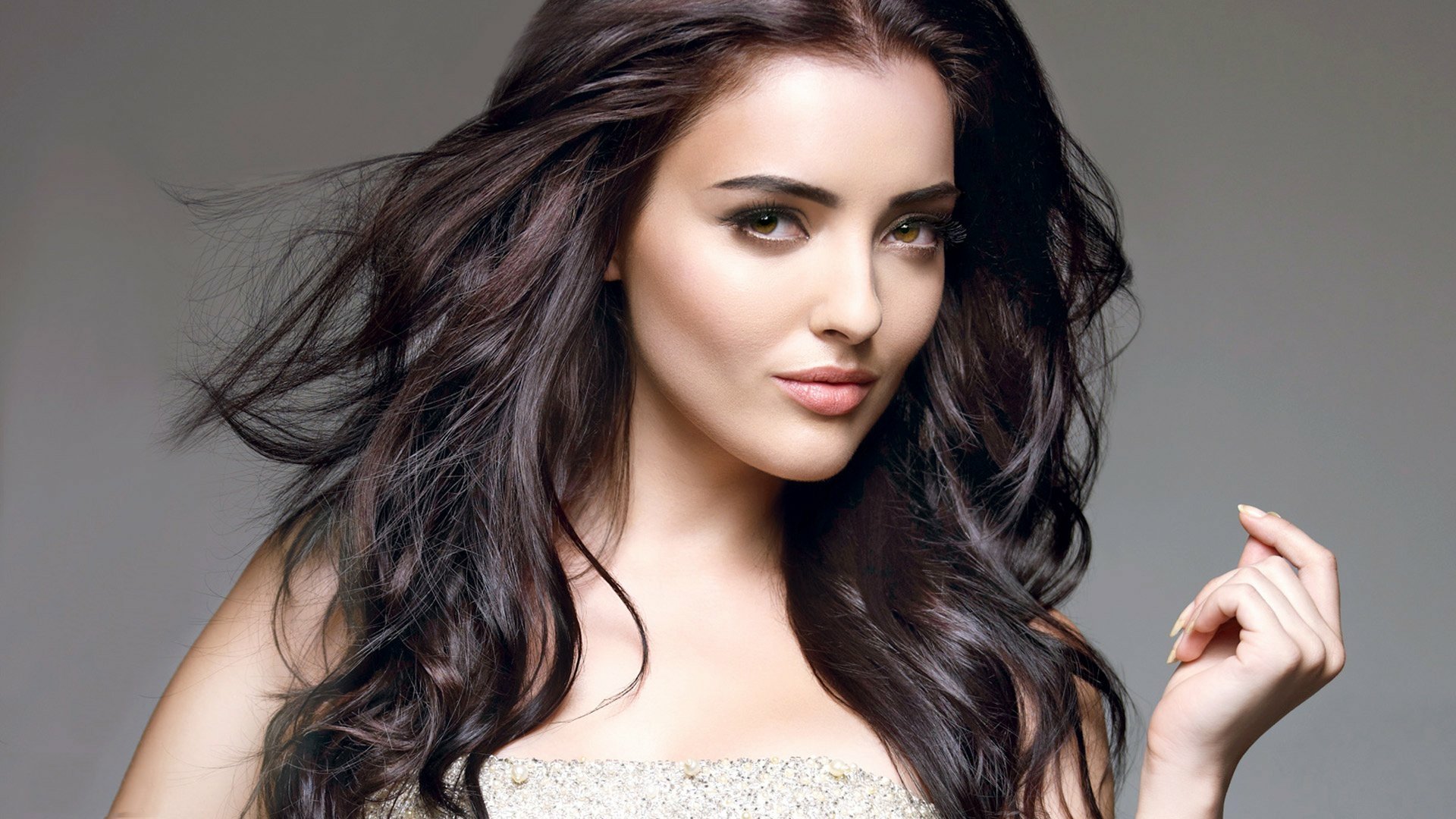 HD desktop wallpaper of a brunette model woman with flowing hair and a confident expression, featuring Kristina Akheeva’s face prominently against a neutral background.