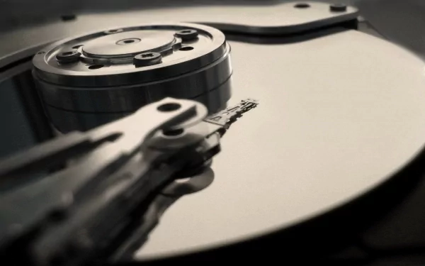 Close-up HD wallpaper of a computer hard disk drive's internal hardware, showcasing its intricate technology components in sharp detail.
