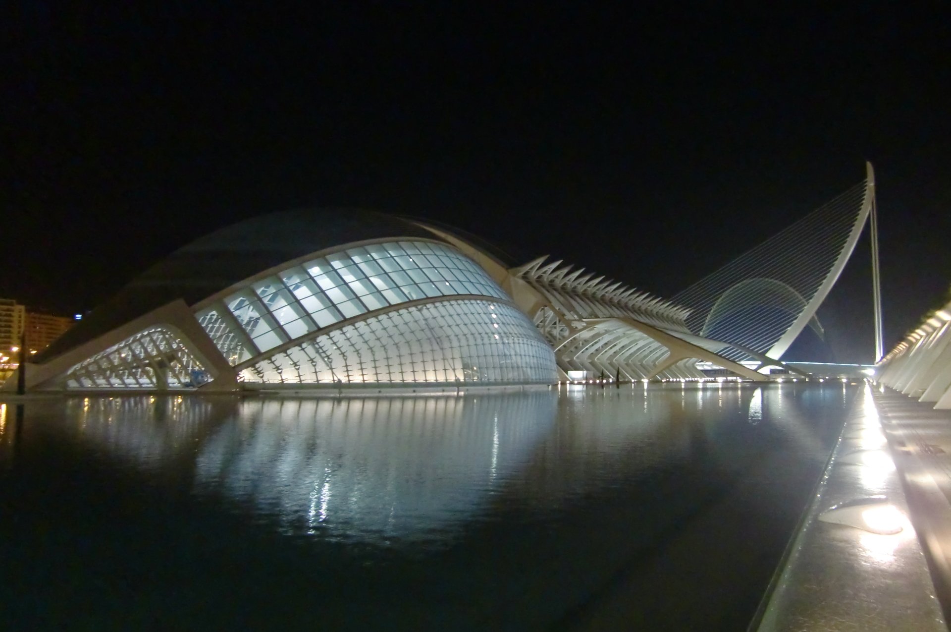 4K Ultra HD PC desktop wallpaper and background: man-made futuristic waterfront architecture at night, illuminated curved glass structures reflected in calm water.