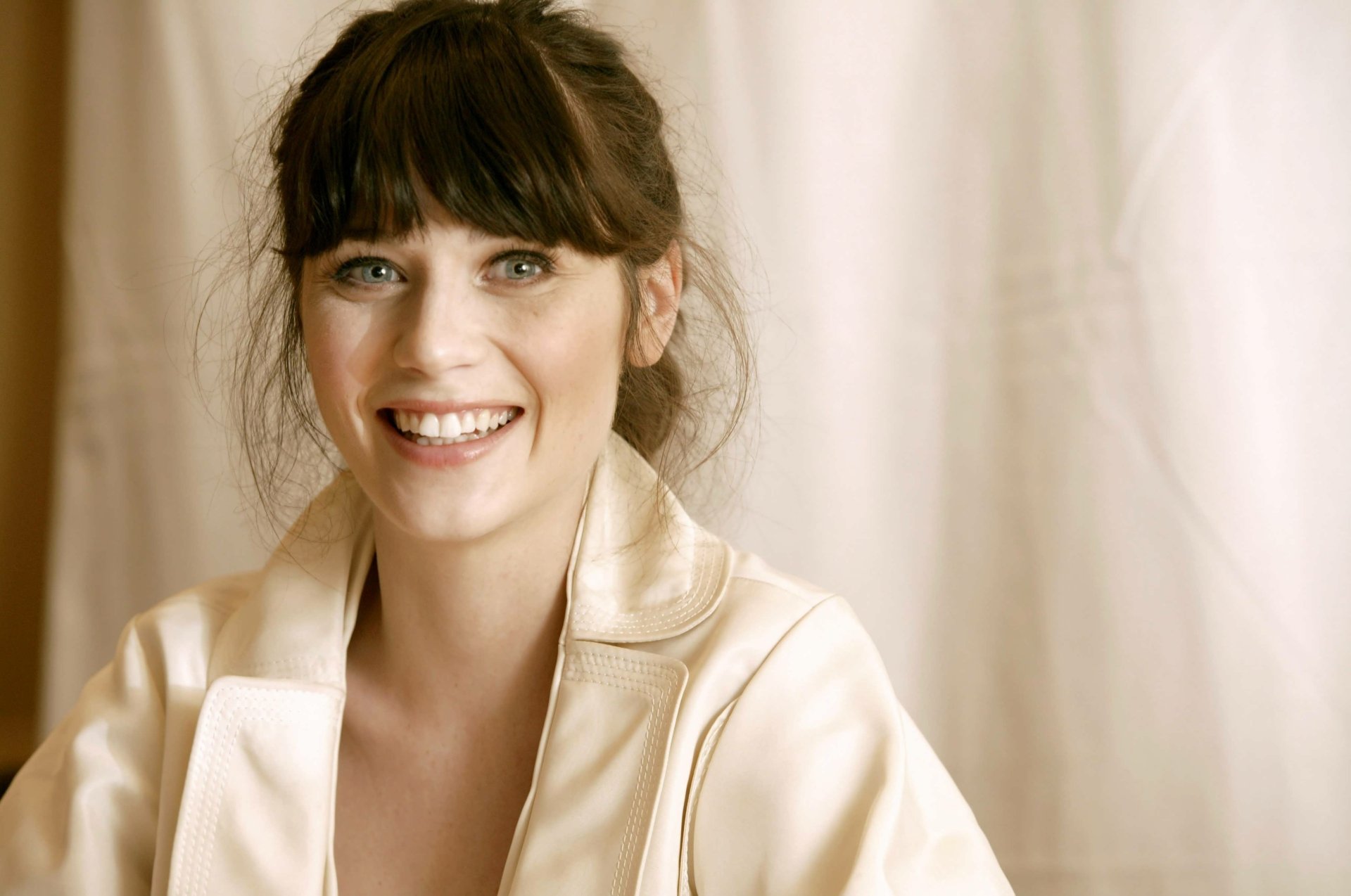 Smiling female celebrity with dark bangs in a satin robe against a soft neutral backdrop — 4K Ultra HD PC desktop wallpaper.