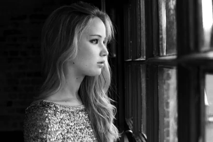 Black and white HD wallpaper featuring a celebrity in a sequined dress, gazing out a window.