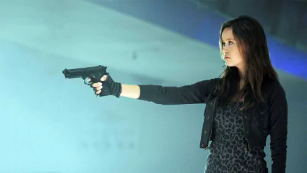 HD desktop wallpaper featuring Summer Glau as Cameron Phillips from the TV show Terminator: The Sarah Connor Chronicles, aiming a gun in a tense scene.