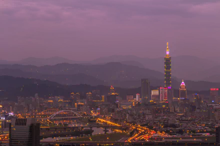 Night cityscape of Taipei, Taiwan featuring the man-made skyline and illuminated Taipei 101 rising above urban lights and distant mountains — 5K Ultra HD PC desktop wallpaper.