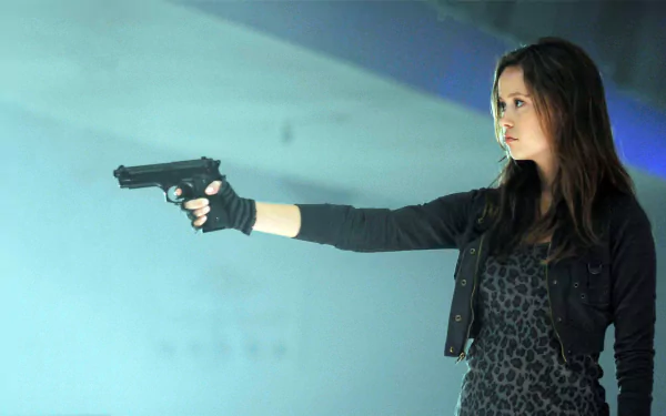 HD desktop wallpaper featuring Summer Glau as Cameron Phillips from the TV show Terminator: The Sarah Connor Chronicles, aiming a gun in a tense scene.