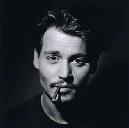 Black and white HD desktop wallpaper featuring Johnny Depp, with a cigarette in his mouth, capturing his intense gaze and iconic style.